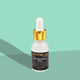 L'orena Ultra Night Repair Serum bottle with dropper on a green background